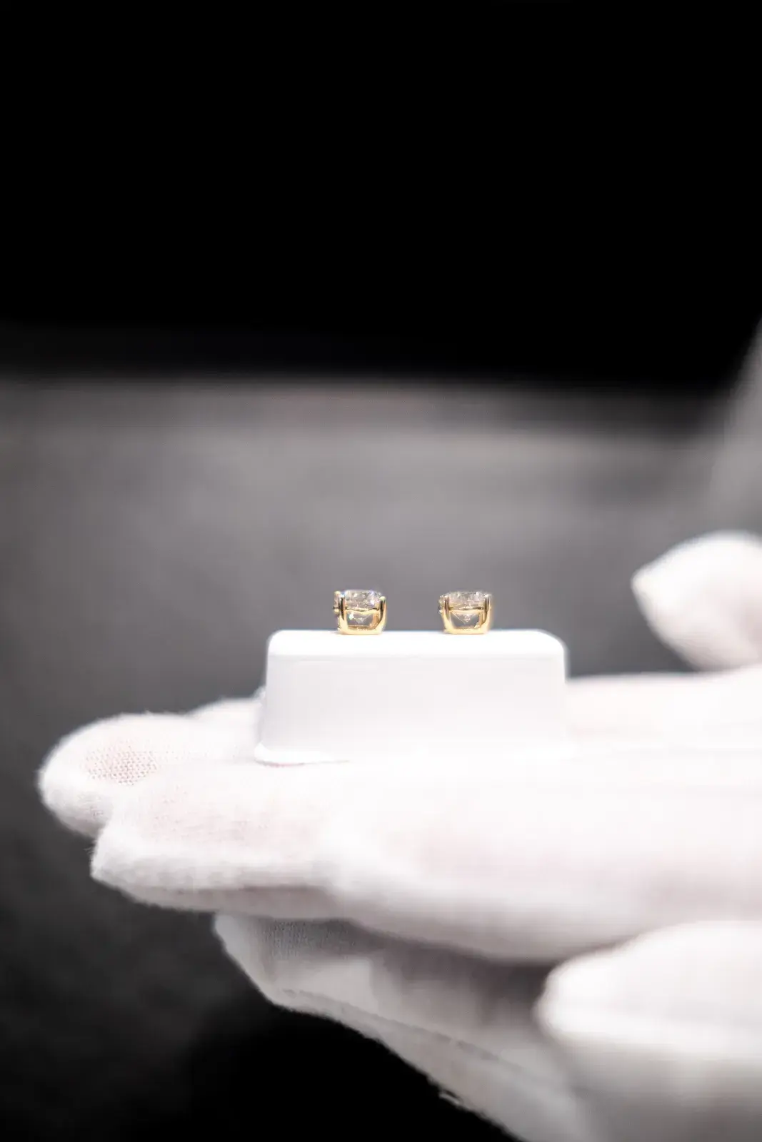 A pair of diamond studs, presented